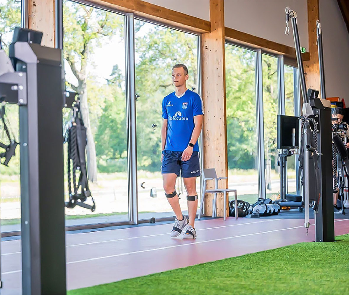 Image of an athlete walking with sensors on his legs