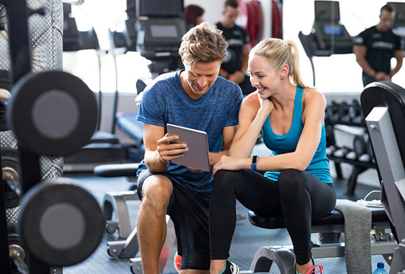 Man and woman in gym looking at an iPad